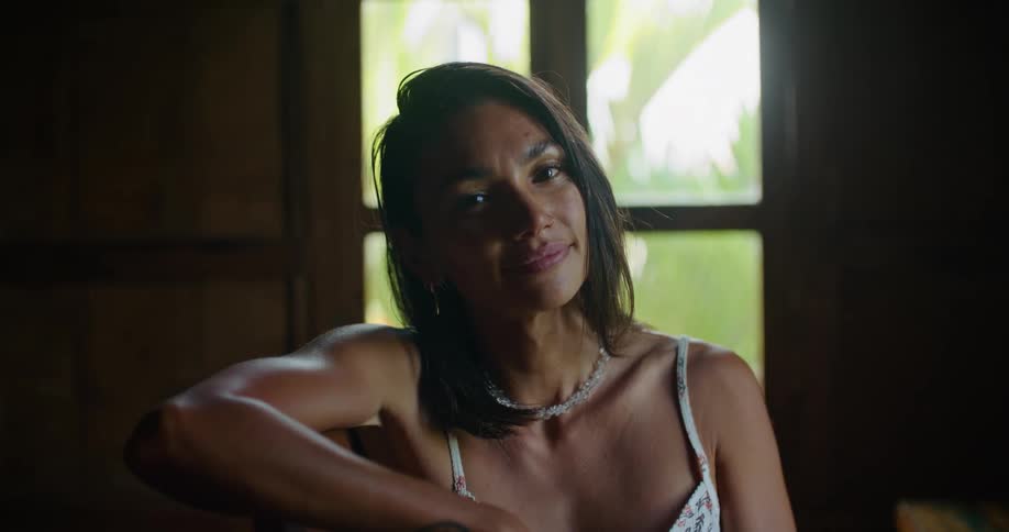 Young pretty woman sitting in front of a window and smiling