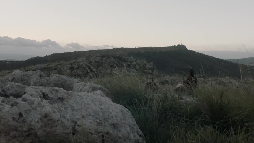 People travel over hills on a windy day