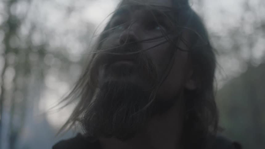 A man looks around on a windy day