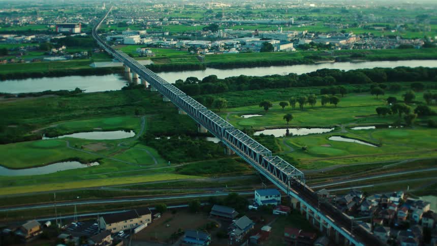 An aerial view of a commuter train traveling through a small town