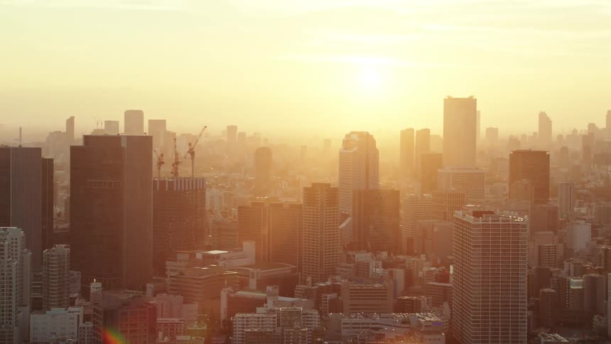 A bright golden sun shining on city skyscrapers and rooftops