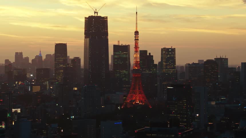 A tower is lit up in red in a city skyline