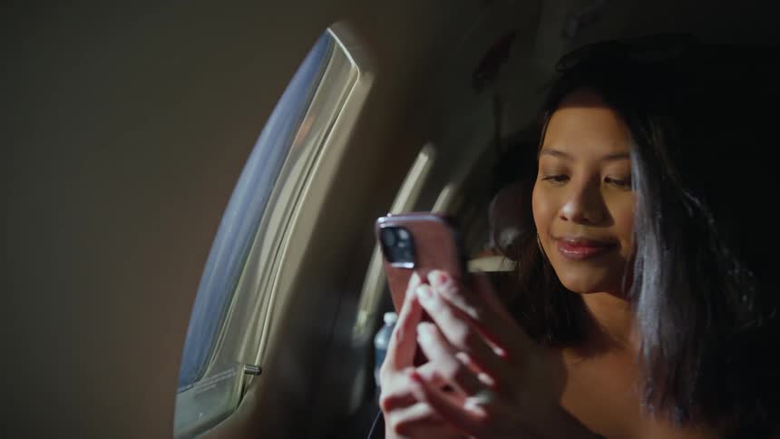 A woman takes a photo from inside the plane