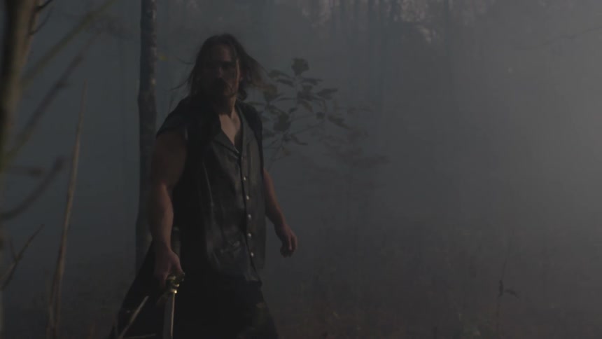 A man is walking through a foggy forest