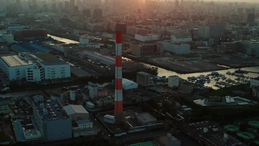 A striped tower sits near a marina in a congested city