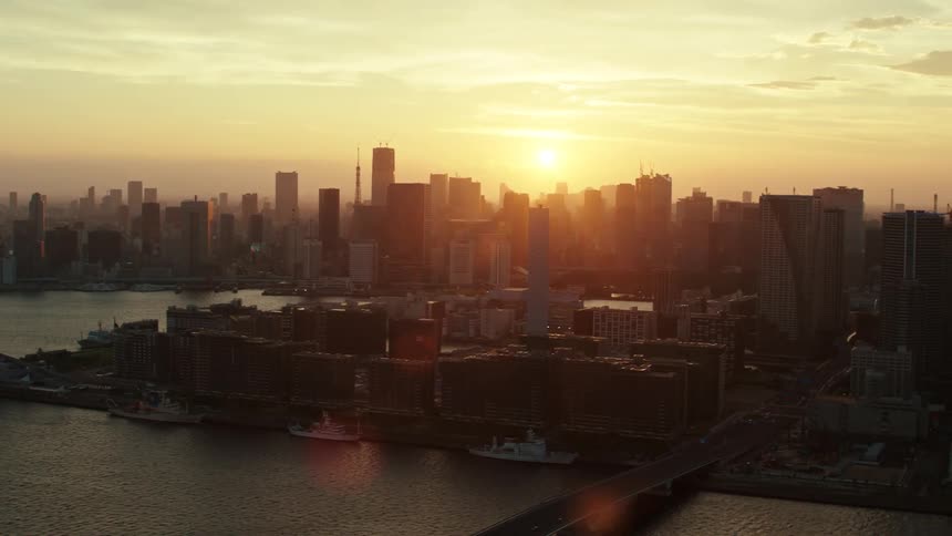 Aerial view of tall skyscrapers on the skyline of a waterfront city at evening