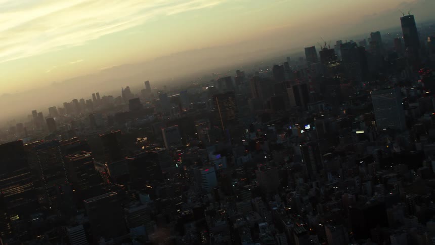 The setting sun is obscured by heavy smog over a city