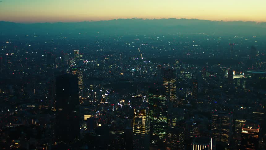 An aerial view of city buildings and skyscrapers at sunrise