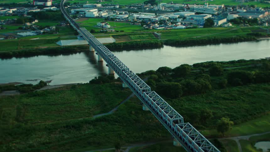 A train travels across the bridge towards town