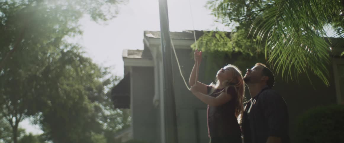 A father and daughter raise the flag together