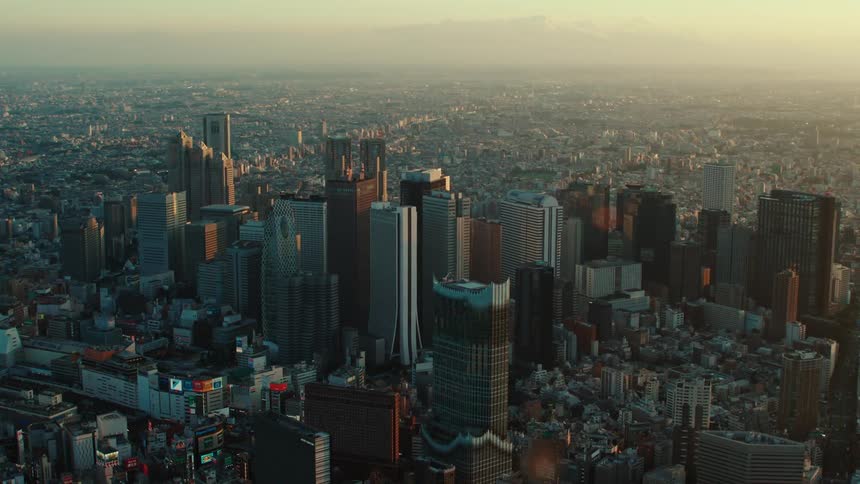 An aerial view of office buildings in a city as the sun rises