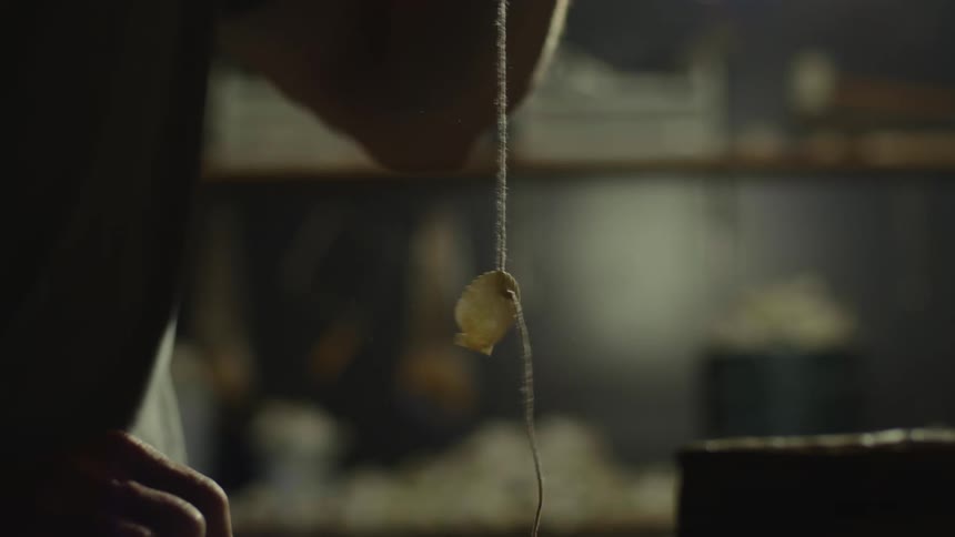 A man pulls up a string and a seashell is attached to it