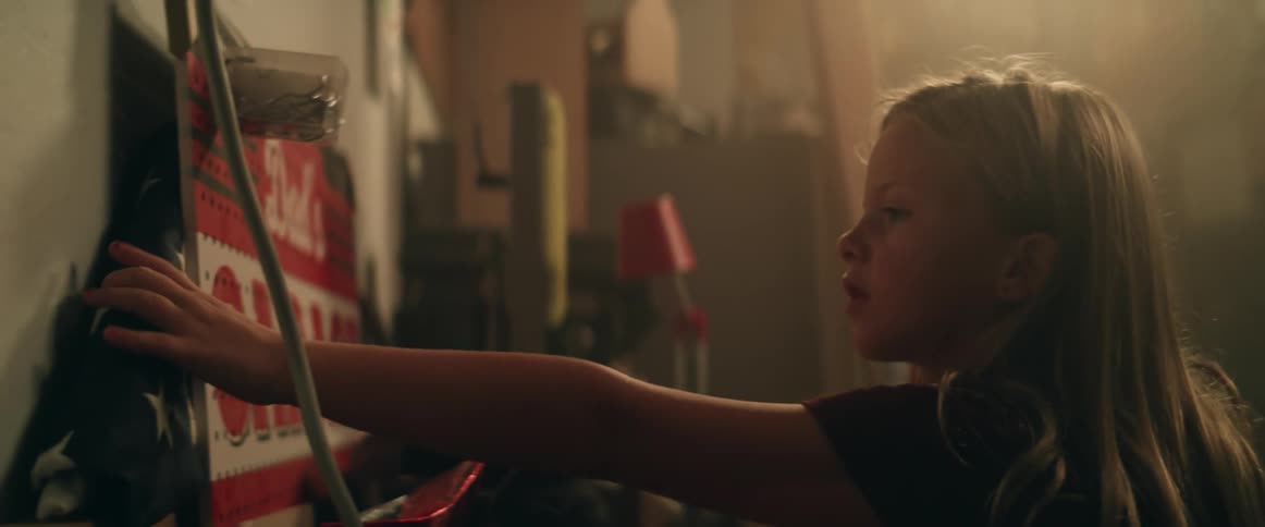 Young girl searching in the garage picks up an american flag from behind a sign