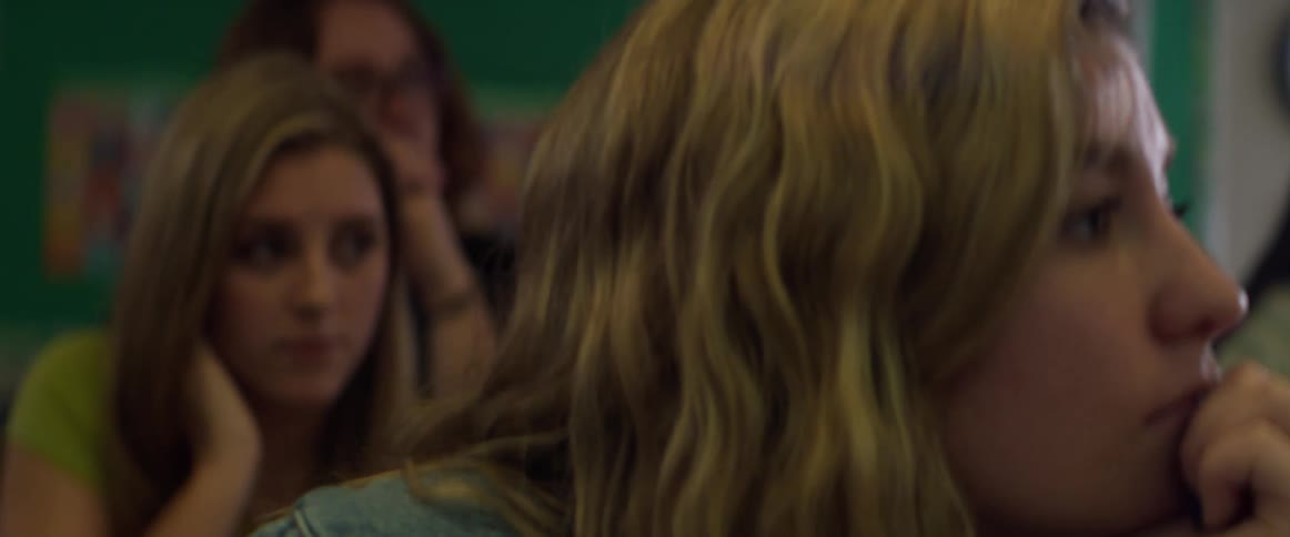Close up of the faces of students sitting on a classroom listening to a professor