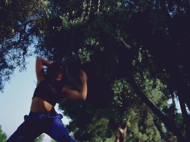 Footage of a woman dancing outdoors during spring