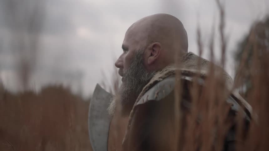 Man holding an ax sitting in a field