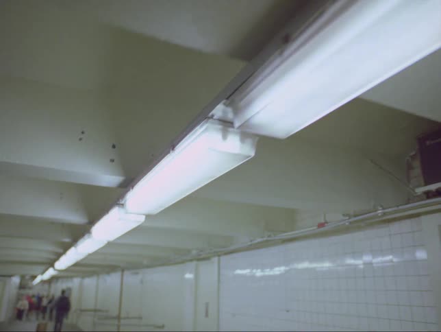 People walk through an underground hallway in a building