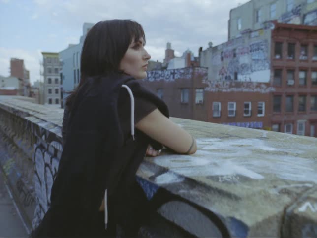 There is a young woman standing in front of a view of the downtown area