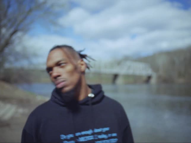 A man nods and walks away from the river