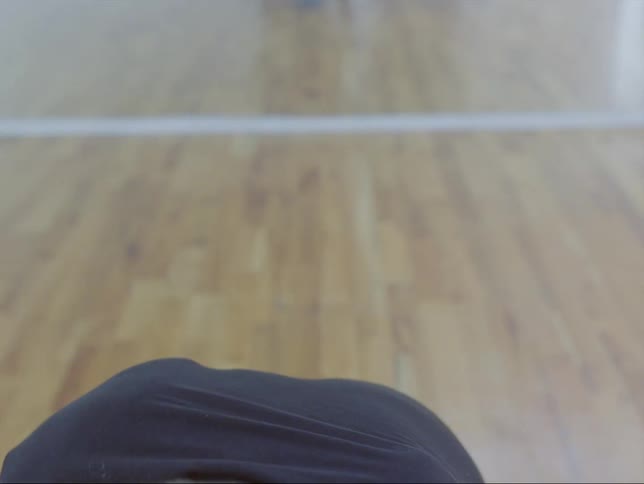 A man in a dance studio spins kneels and looks up