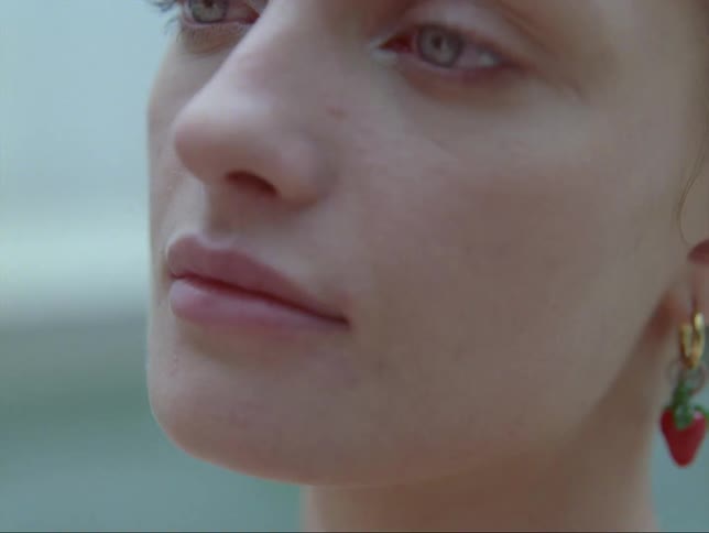 A young woman sitting in a pool of water looks up at the sky