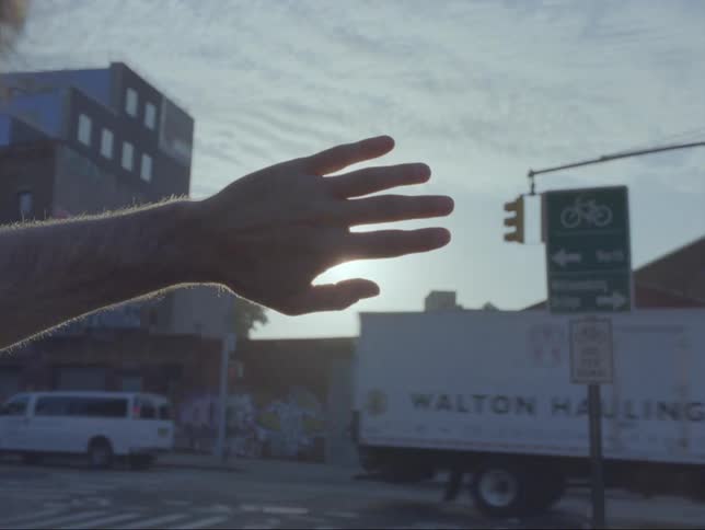 A person is standing outdoors in a city during dusk