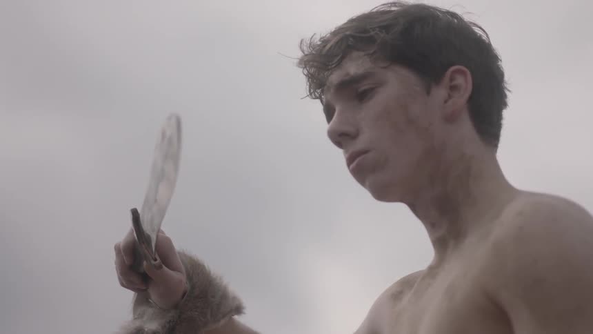 A man examines a sword in his hand