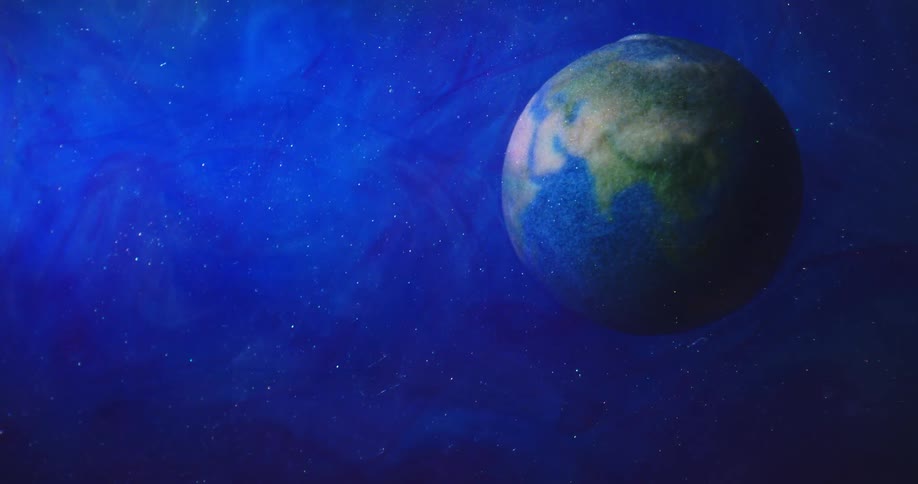 A blue and green sphere floats in an electric blue space with twinkling stars