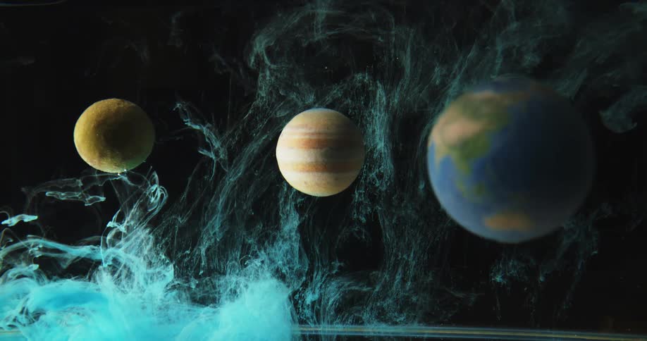 Smoke rises up and around a model of planets