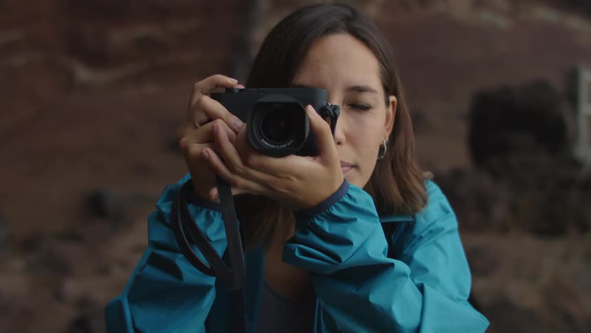 A teenage girl takes a photo outdoors