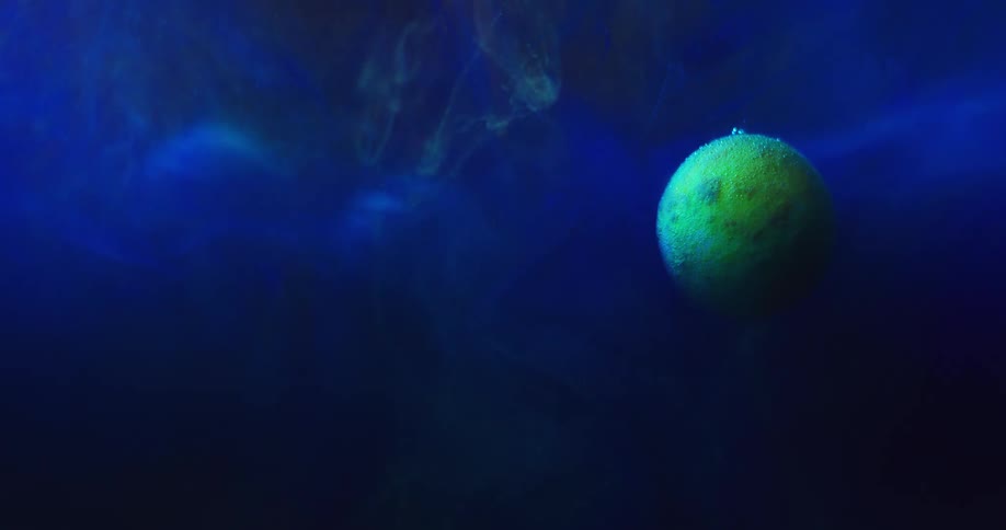 A neon green sphere is floating an organic electric blue atmosphere as wisps of green ghost trails fall from above