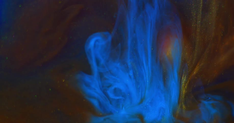 A blue liquid drops into red liquid then as it moves down an orb is revealed