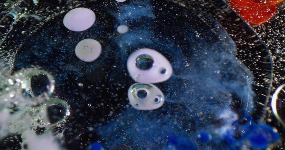 Bubbles are floating in a dark area with foam and a blue cloud blending in