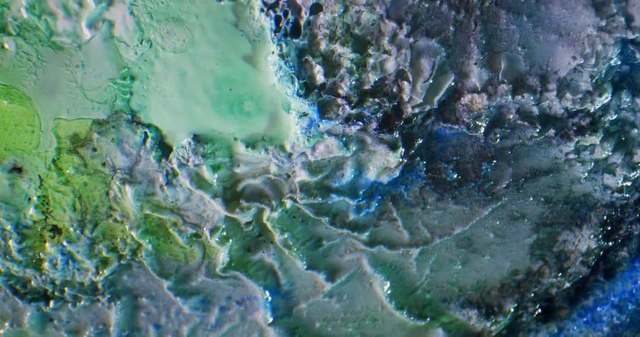 Pale textured surface is dabbed with greens and blues