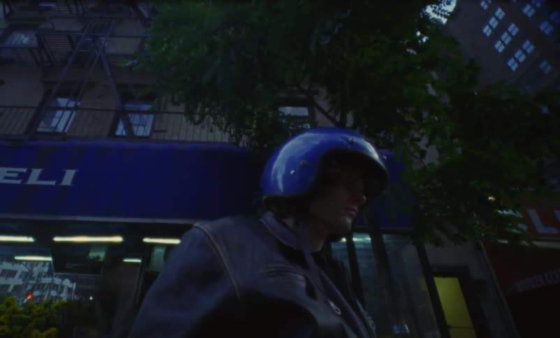 A man is putting on a helmet in an urban city