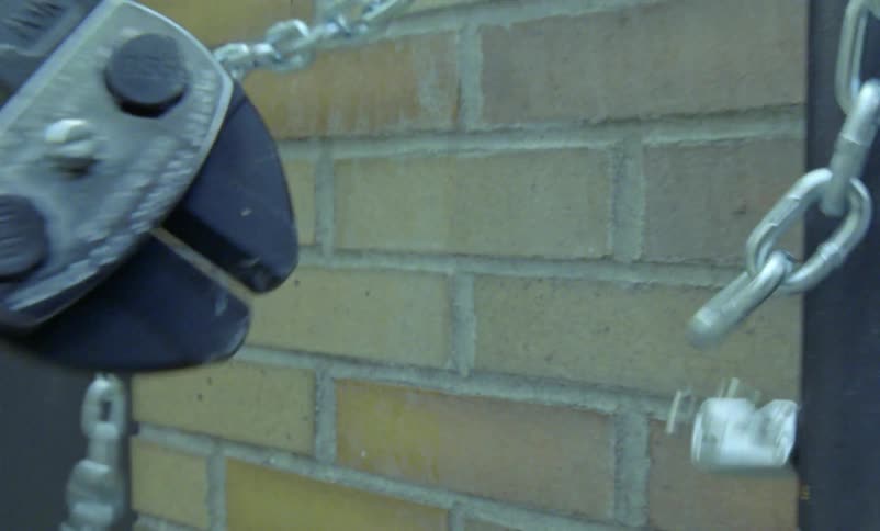 A tool being used to cut a lock off a chain