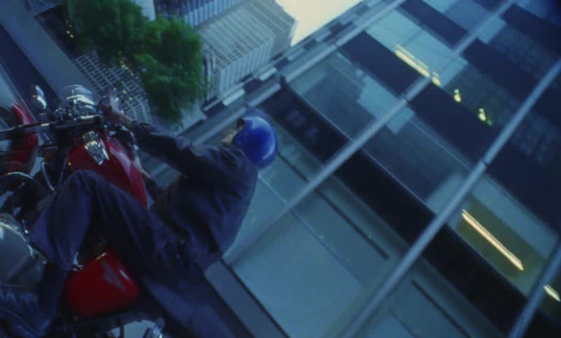 A person is riding a motorcycle in a city during spring