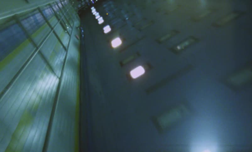 Chaotic footage of a vehicle driving out of a tunnel in the city at night caught on vintage film