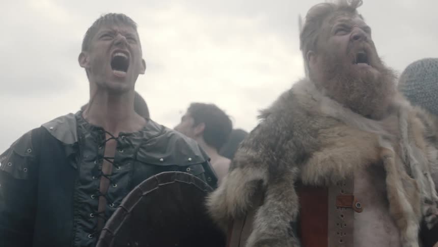 Men carrying weapons shout and beat at their shields