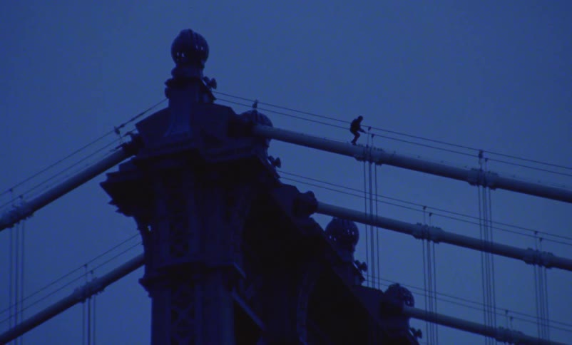 Someone is walking on top of a suspension bridge