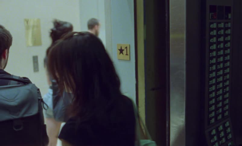 There is a few people that are walking out of a elevator