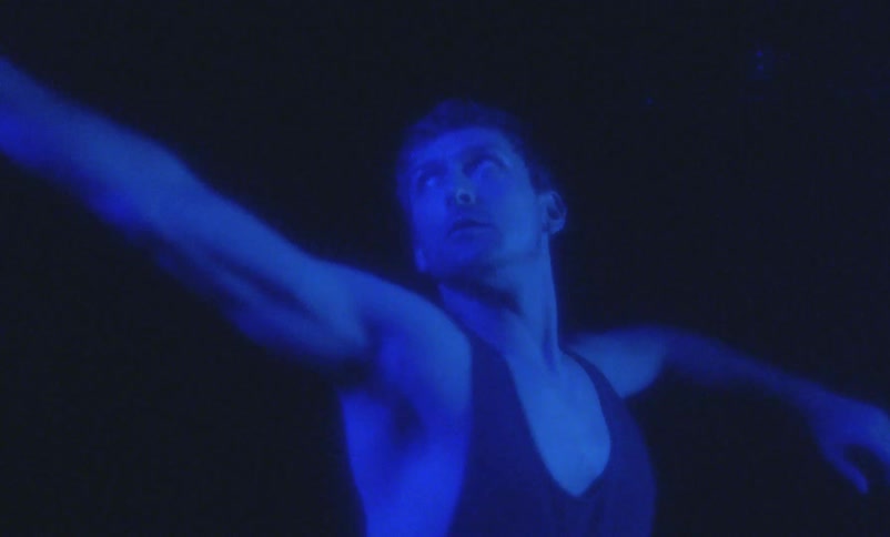 A man is in a room and is dancing