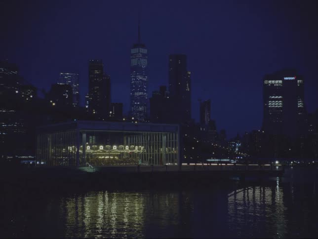 Lit up office buildings in a city on the waterfront at night
