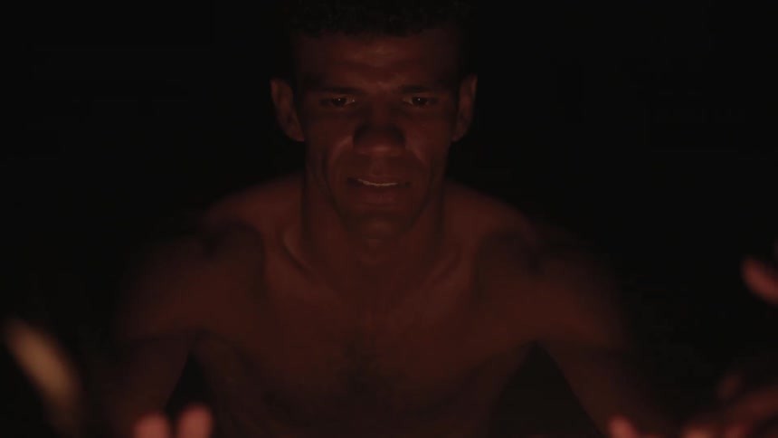 A man is warming his hands by a fire at night