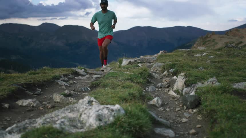 A man is running by the mountains