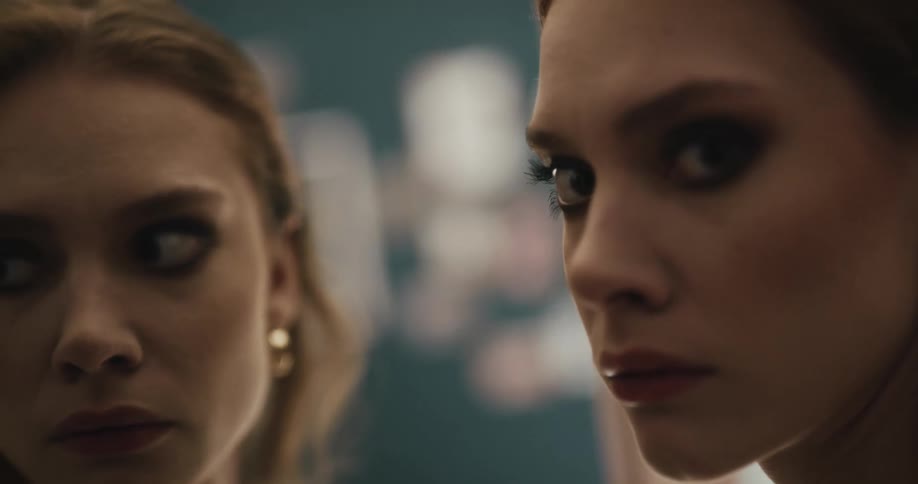 Two nervous looking teens turn there heads and look in to the distance