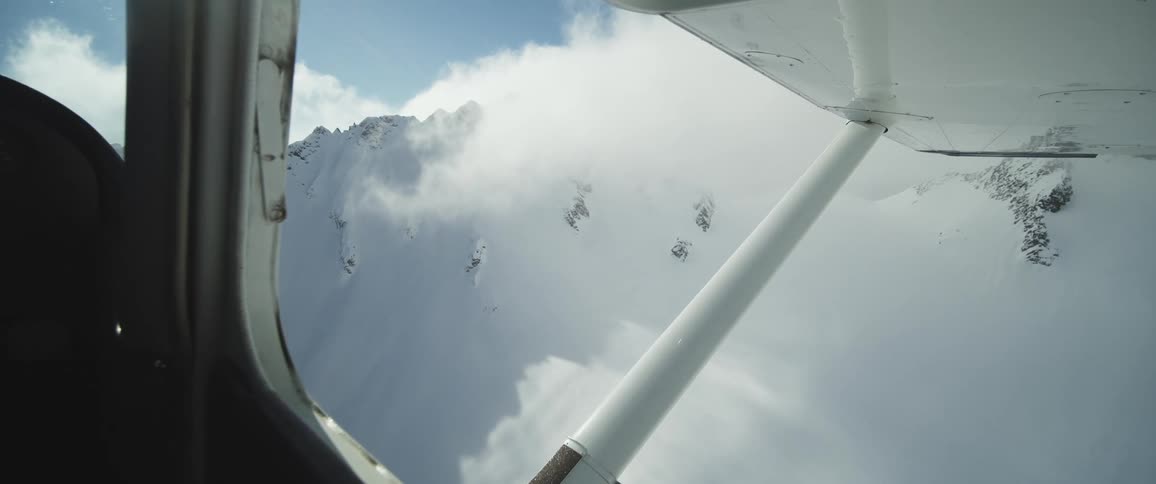 Clouds over a mountain range seen out of an airplane