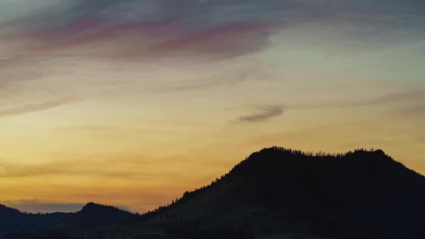 Mountains are silhouetted agains the red sky at dusk