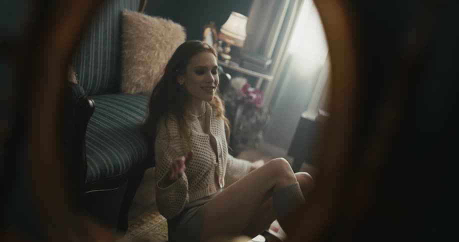 A woman is sitting on the floor of a room dancing