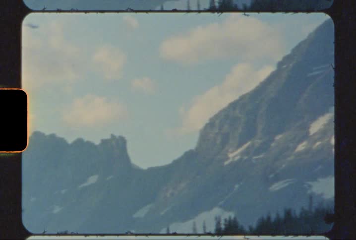 A view of mountain peaks at sunset in glacier national park shot on 8mm film